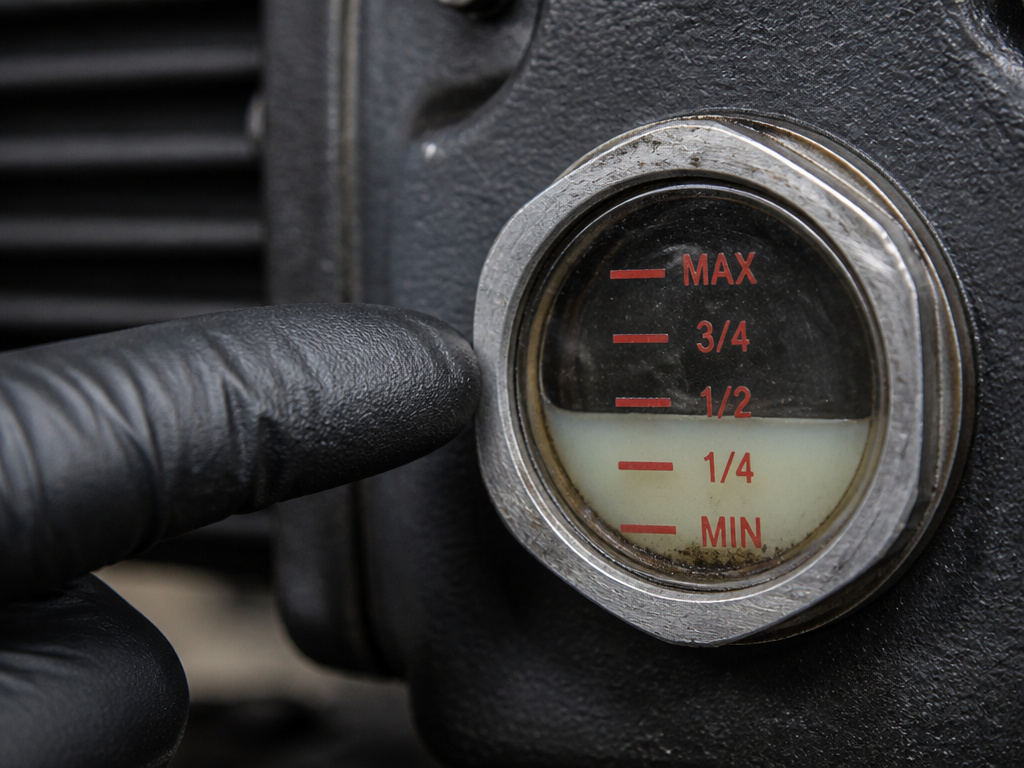 Close-up of milky, degraded oil in a vacuum sealer pump sight glass.